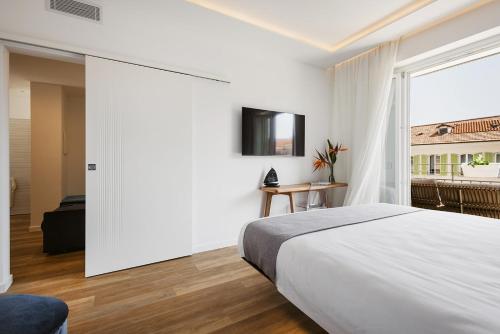 a white bedroom with a bed and a window at Sanremissimo Rooms & Apartment in Sanremo