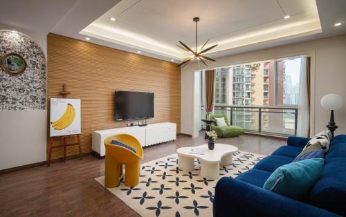 a living room with a blue couch and a tv at 重庆乐隐江景民宿 in Chongqing