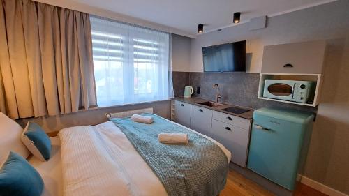 a small kitchen with a bed and a microwave at Willa Marion in Karpacz