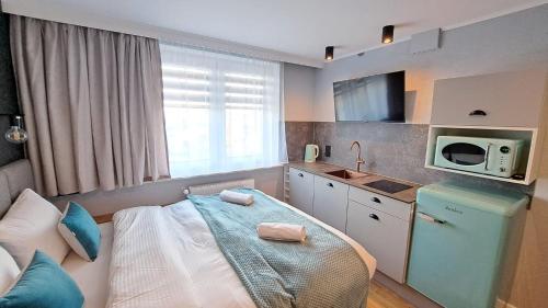 a small kitchen with a bed and a microwave at Willa Marion in Karpacz