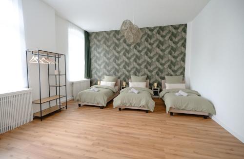 a room with four beds in it with a wall at City-Apartment am Osternburger Marktplatz in Oldenburg