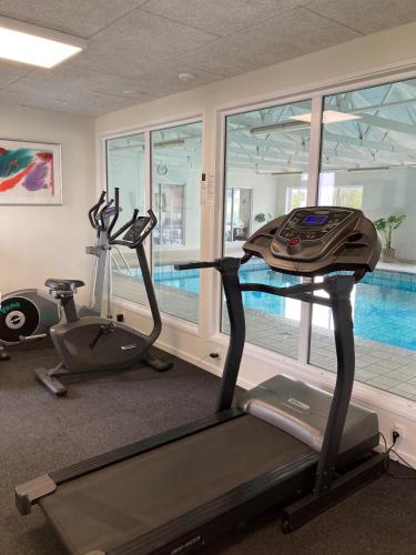 a gym with two exercise bikes and a swimming pool at Hotel Tannishus in Bindslev