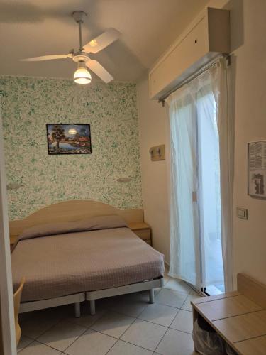 a bedroom with a bed and a window at Hotel Romagna in Cattolica