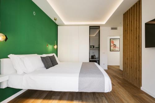 a bedroom with a white bed and a green wall at Sanremissimo Rooms & Apartment in Sanremo