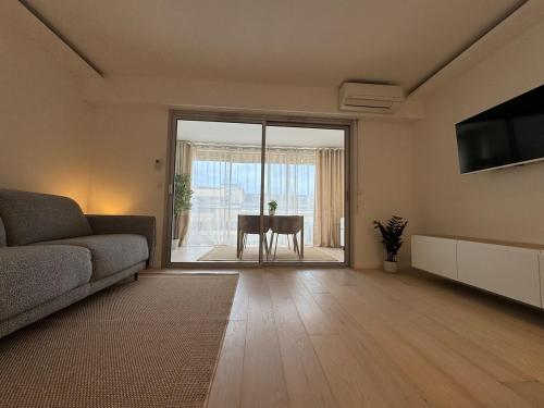 un salon avec un canapé et une table dans l'établissement Le Regina - Apt standing 2 Prs - Clim - Parking, à Antibes