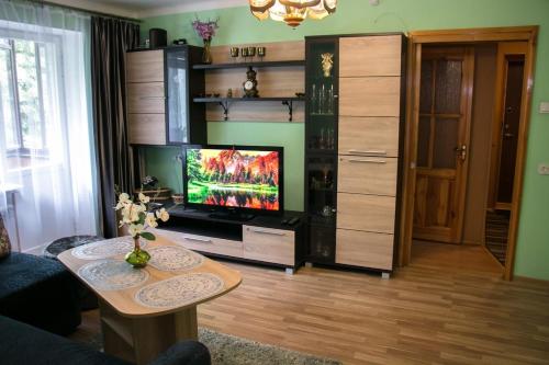 a living room with a tv and a table at Comfy Bright Apt in OLD TOWN Your Perfect Location in Vilnius