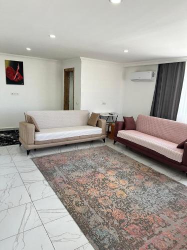 a living room with two couches and a rug at Demre Asya Apart in Demre