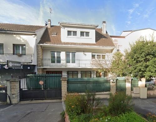 a large white house with a fence in front of it at COSY BIG HOUSE near Paris, Roissy, big parking in Le Blanc-Mesnil