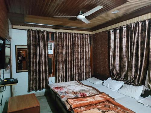 a bedroom with a bed and a window with curtains at Singh Hotel's Shubhadra Boutique Stay in Mathura