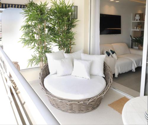- un fauteuil en rotin avec des oreillers dans le salon dans l'établissement Beautiful apartment with panoramic sea view, à Antibes