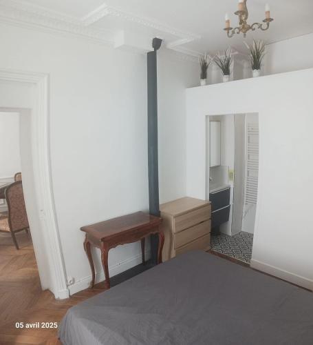 une chambre avec un lit, une table et un miroir dans l'établissement Ternes - Parisian appartment, à Paris