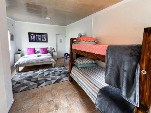 a bedroom with two bunk beds and a rug at Hermanus Backpackers & Budget Accommodation in Hermanus