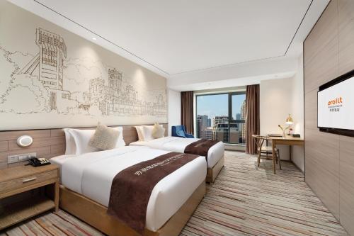 a hotel room with two beds and a flat screen tv at Chengdu Prolit Hotel in Chengdu