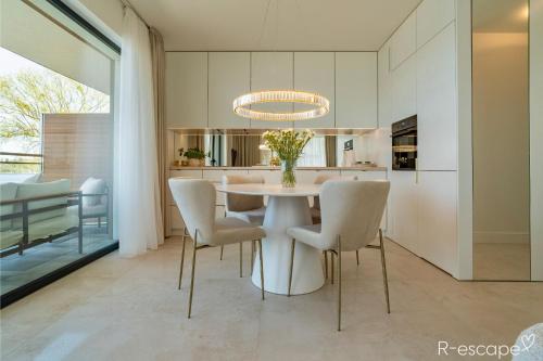 a dining room with a white table and chairs at R-escape Apartamenty Ostróda in Ostróda