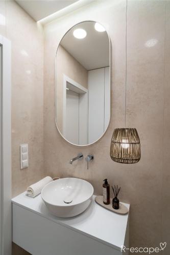 a bathroom with a sink and a mirror at R-escape Apartamenty Ostróda in Ostróda