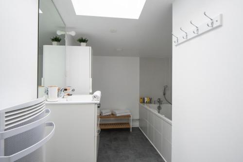 une cuisine blanche avec des armoires blanches et un réfrigérateur dans l'établissement Amazing and Quiet Duplex in the City Center !, à Lille