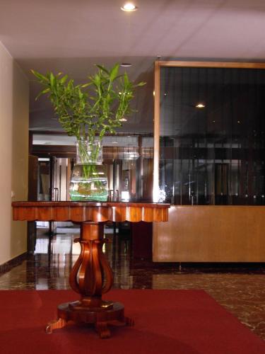 a vase with a plant on a wooden table at Hotel Best in Ankara