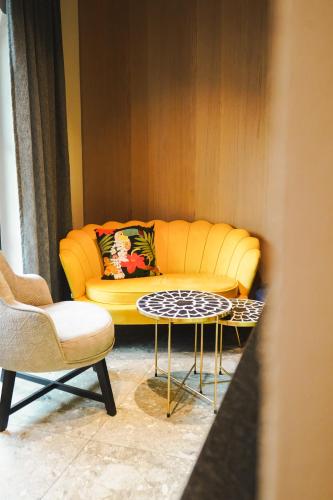 a living room with a yellow couch and a table at Boutique House happYellow Saalbach, inkl JokerCard in Saalbach Hinterglemm