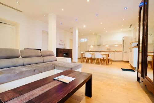 un salon avec un canapé et une table dans l'établissement Les Muguets - Apt Standing 4 Prs - clim, parking, à Vallauris