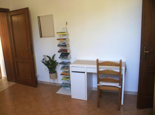 a room with a desk and a chair and a shelf of shoes at Geoglobe Apartment in Pisa