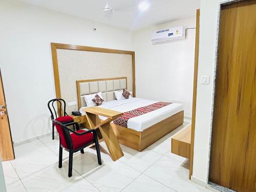 a bedroom with a bed and a table and chairs at Hotel The Aadimata & Banquets in Chittaurgarh
