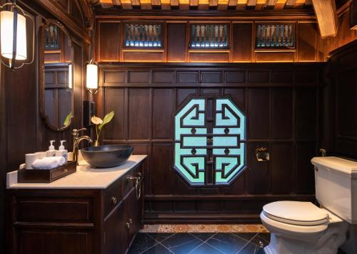 a bathroom with a toilet and a sign on the wall at Ancient Huế Garden Houses in Hue