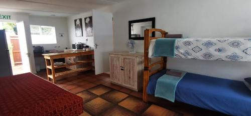 a bedroom with a bunk bed and a desk at Hermanus Backpackers & Budget Accommodation in Hermanus