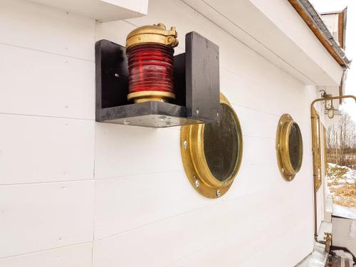 a red and gold light hanging on a wall at Cozy little house with sauna on a fishing boat in Pärnu