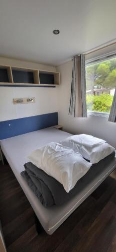 un lit dans une petite pièce avec une fenêtre dans l'établissement Location Mobil home, à Torreilles