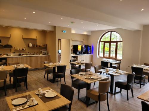 un restaurant avec des tables et des chaises en bois et une cuisine dans l'établissement Sure Hotel by Best Western Saint-Quentin Ouest Le pot d étain, à Holnon