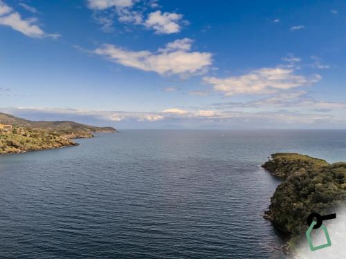 an island in the middle of a body of water at HOTIDAY Room Collection - Porto Azzurro in Capoliveri