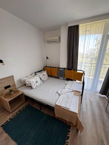 a bedroom with a bed and a large window at Студия 310 и 312 на първа линия in Chernomorets