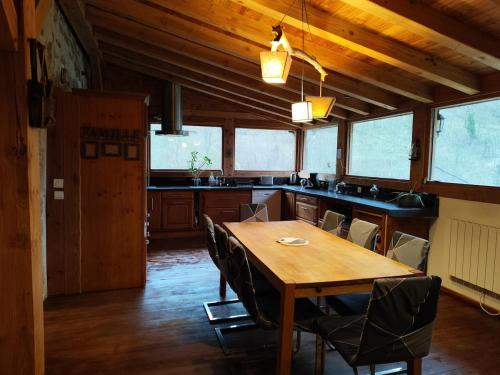 a large kitchen with a wooden table and chairs at Gite Au Coeur d'Allary près de la Dolce Via in Saint-Cierge-sous-le-Cheylard