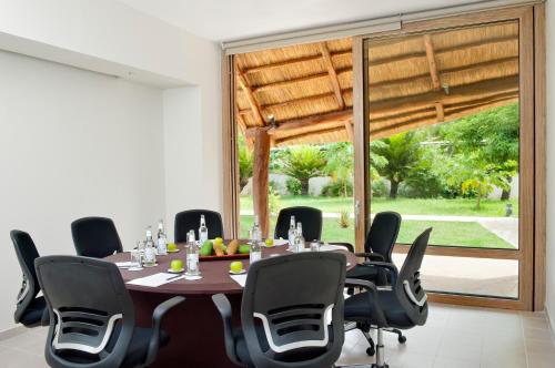 a conference room with a table and black chairs at Melia Zanzibar in Kiwengwa