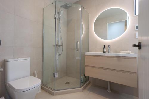 a bathroom with a shower and a toilet and a sink at Luxury Stay in Central Takapuna in Auckland