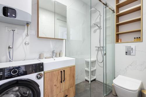 a bathroom with a washing machine and a shower at Apartment FORTUNELLA in Becici