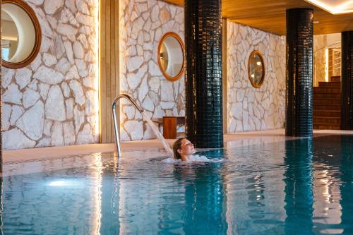 a woman in a swimming pool at a hotel at Seth Santo Tomás in Santo Tomás