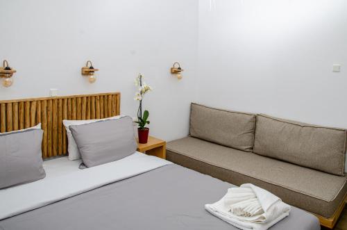 a bedroom with two beds and a couch at Hotel Livadia in Parikia
