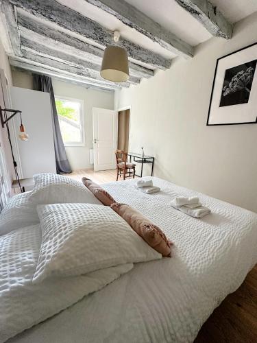 une chambre avec un grand lit blanc dans une pièce dans l'établissement Gites-domainedupin, gîte de la Closerie, à Mosnes