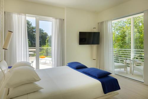 a bedroom with a large bed and a balcony at Versilia Lido | UNA Esperienze in Lido di Camaiore