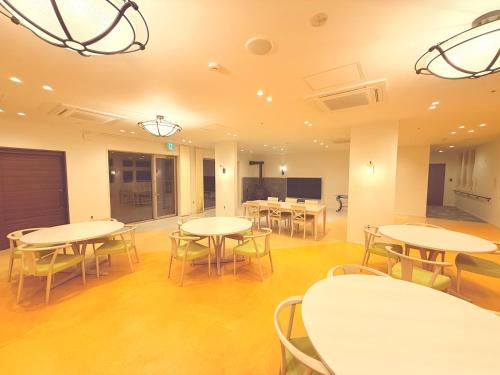 a room with tables and chairs in a building at The Noborisaka Village -登り坂ビレッジ- in Fujikawaguchiko