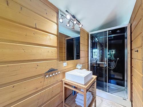 La salle de bains est pourvue de murs en bois, d'un lavabo et d'une douche. dans l'établissement Chez Pim's, à Hyères