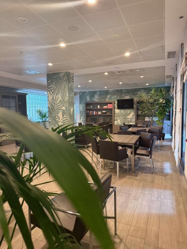a dining room with tables and chairs and plants at Best Western Plus Borgolecco Hotel in Arcore
