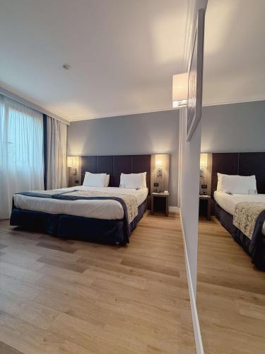 a hotel room with two beds and a window at Best Western Plus Borgolecco Hotel in Arcore