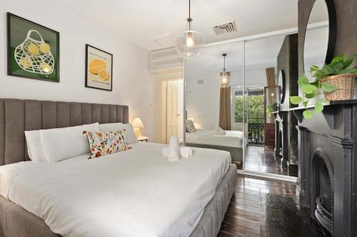 a bedroom with a white bed and a fireplace at Holiday Home with Outdoor Area for 8 Guests in Sydney