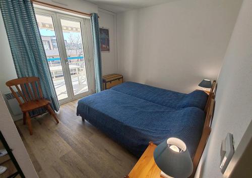 une chambre avec un lit bleu et une fenêtre dans l'établissement Très belle T2, vue mer ,Le Tout a Pied, à Saint-Raphaël