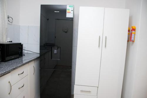 a small kitchen with a microwave and a refrigerator at Optimum Stay Self Catering Accommodation - Deluxe Room in Cape Town