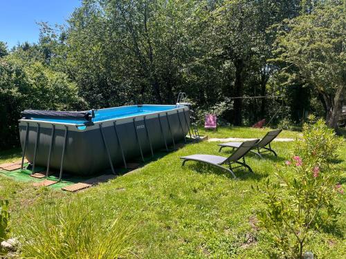 un petit bateau assis dans l'herbe avec deux chaises dans l'établissement Les pierres de Fonfage, à Boissezon