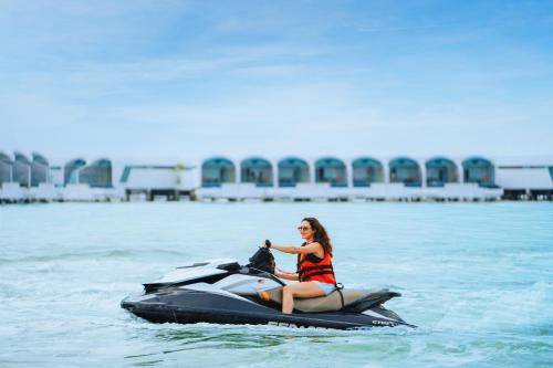 a woman riding a jet ski in the water at Lexis Hibiscus Port Dickson in Port Dickson