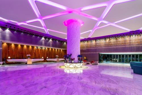 a large lobby with a column and purple lighting at Lexis Hibiscus Port Dickson in Port Dickson